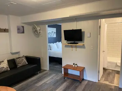a living room with a couch and a bed and a television at Pinewood Inn in Golden