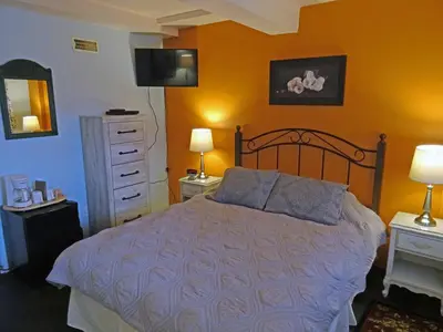 a bedroom with a bed and two lamps and a dresser at Eagle's Nest Resort in Anahim Lake