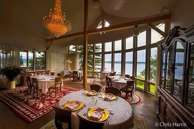 a dining room with tables and chairs and a chandelier at Eagle's Nest Resort in Anahim Lake