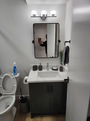 a bathroom with a sink and a mirror and a toilet at Super luxury suite in Edmonton