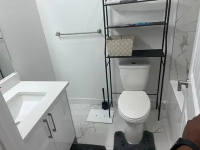 a bathroom with a white toilet and a sink at Midas Haven in Edmonton