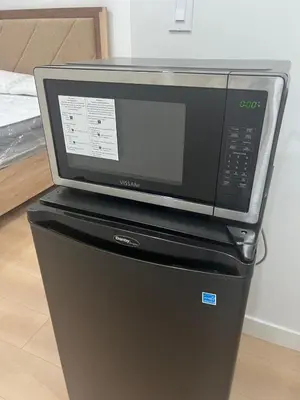 a microwave sitting on top of a refrigerator at Midas Haven in Edmonton