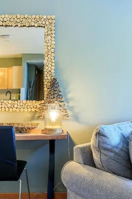 a living room with a table and a mirror at Summit at The Lodges of Canmore in Canmore