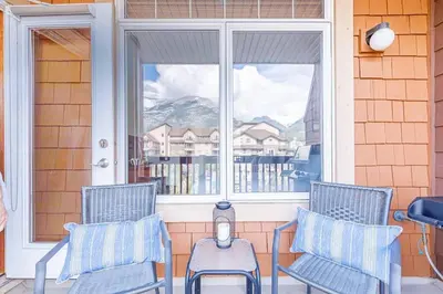 two chairs sitting on a porch with a window at Mountain Paradise at Falcon Crest Lodge in Canmore
