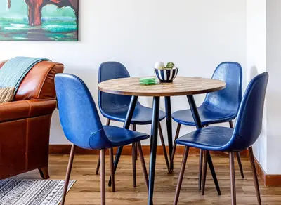a table and chairs with blue chairs around it at Mountain Paradise at Falcon Crest Lodge in Canmore