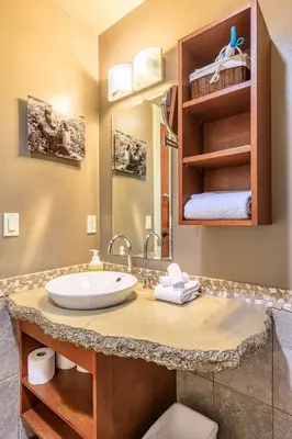 a bathroom with a sink and a shelf with towels at Serene Spruce at Solara Resort in Canmore