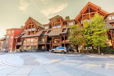 a car parked in front of a large building at Serene Spruce at Solara Resort in Canmore