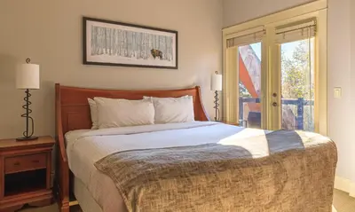 a bedroom with a bed and a window at Serene Spruce at Solara Resort in Canmore