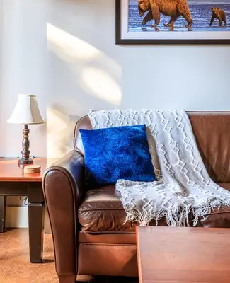 a brown leather couch with a blue pillow on it at Serene Spruce at Solara Resort in Canmore