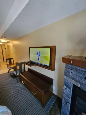 a hotel room with a tv and a fireplace at Falcon Crest Canmore Banff in Canmore