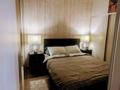 a bedroom with a large bed with two lamps on both sides at Breath Taking View for 4Guest DTskyline-22nd Floor in Calgary