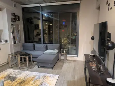 a living room with a couch and a large window at Breath Taking View for 4Guest DTskyline-22nd Floor in Calgary