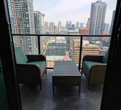 a balcony with chairs and a table and a view of a city at Breath Taking View for 4Guest DTskyline-22nd Floor in Calgary