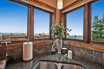 a kitchen with a sink and windows with a view at Snow Therapy Chalet - Ski In Out, Hot Tub & Mtn View in Big White