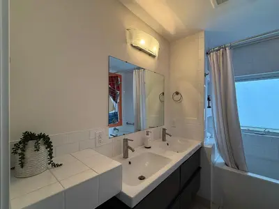 a white bathroom with a sink and a mirror at 2Bed Bright & Stylish Ritchie Urban Retreat in Edmonton