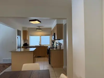 a kitchen with wooden cabinets and a counter top at 2Bed Bright & Stylish Ritchie Urban Retreat in Edmonton
