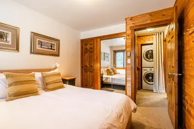 a bedroom with a bed and a washing machine at Best Location Available in Whistler Village in Whistler