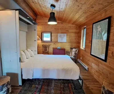 a bedroom with a white bed in a wooden room at Eagle Nest by StayIn in Fairmont Hot Springs