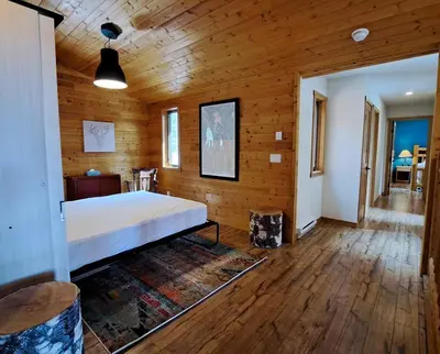 a bedroom with a bed and a wooden wall at Eagle Nest by StayIn in Fairmont Hot Springs