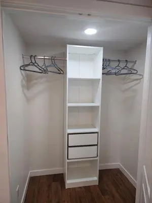 a walk in closet with white cabinets and shelves at Cozy & Spacious 1-Bedroom SW Calgary near SpruceMeadows in Calgary