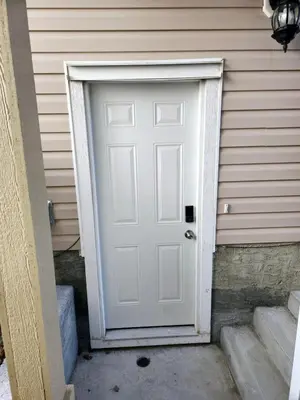 a white door on the side of a house at Cozy & Spacious 1-Bedroom SW Calgary near SpruceMeadows in Calgary