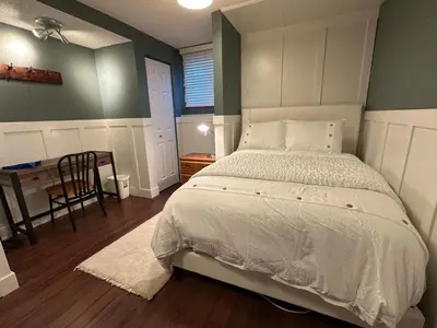 a bedroom with a large bed and a table at 1Bed Cozy Retreat & Spacious Lounge in Yellowknife