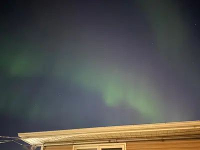 a dark sky above a building with a wall at 1Bed Cozy Retreat & Spacious Lounge in Yellowknife