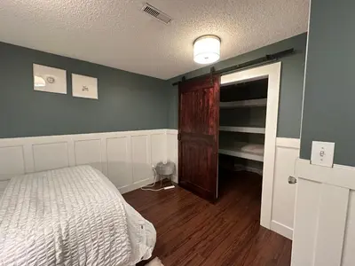 a bedroom with a bed and a wooden closet at 1Bed Cozy Retreat & Spacious Lounge in Yellowknife