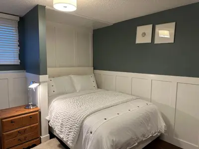 a bedroom with a bed with a blue accent wall at 1Bed Cozy Retreat & Spacious Lounge in Yellowknife