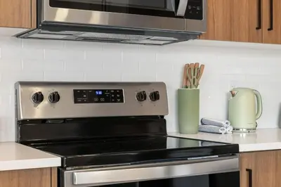 a stove top oven in a kitchen with a microwave at 2 Bedroom Spacious & Private Guest Suite - King Size Bed TV in Room, 58