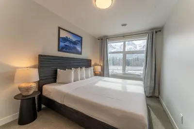a bedroom with a large bed with a window at Skyridge by Canmore Premier in Canmore