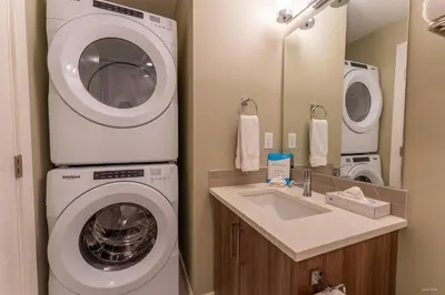 a bathroom with a washing machine and a sink at Skyridge by Canmore Premier in Canmore