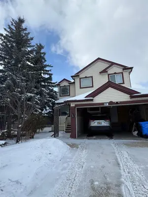 a house with a car garage in the snow at Home Away from Home in Calgary