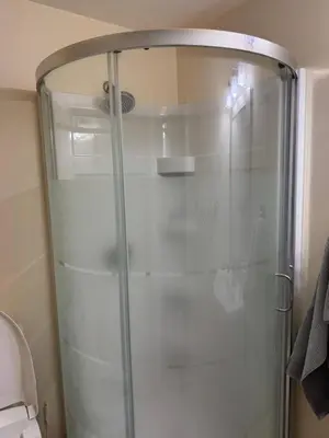 a shower with a glass door in a bathroom at Home Away from Home in Calgary