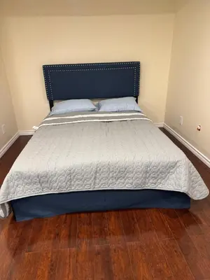 a large bed in a bedroom with a wooden floor at Home Away from Home in Calgary