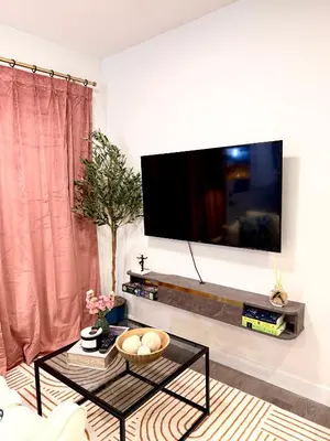 a living room with a flat screen tv on a wall at 2bed Lagos House Backyard Suites Downtown in Edmonton