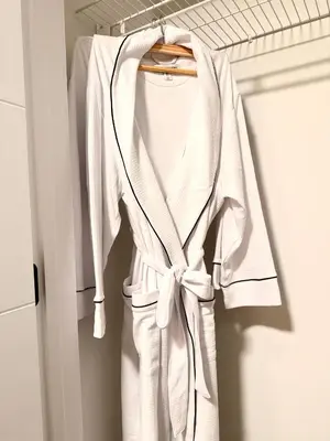 a white robe hanging on a rack in a closet at 2bed Lagos House Backyard Suites Downtown in Edmonton
