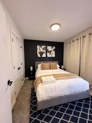 a bedroom with a large bed and a black wall at 2bed Lagos House Backyard Suites Downtown in Edmonton