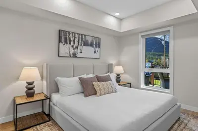 a bedroom with a bed with two lamps and a window at 2 bedrooms-3 beds 2 baths - Rocky Mountain View Retreat - Heated Pool and Hot Tub in Dead Man's Flats