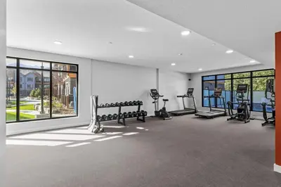 a gym with benches and ellipticals in a room at 2 bedrooms-3 beds 2 baths - Rocky Mountain View Retreat - Heated Pool and Hot Tub in Dead Man's Flats