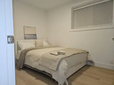 a bedroom with a bed and a window in it at Cozy new Suite in Silver Valley in Maple Ridge District Municipality