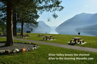 a group of picnic tables in a park next to a lake at Cozy new Suite in Silver Valley in Maple Ridge District Municipality
