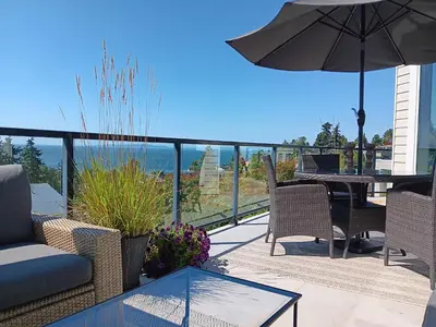 a patio with a table and chairs and an umbrella at Sand and Salt Bed & Breakfast in White Rock