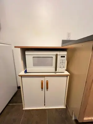 a microwave sitting on top of a white cabinet at Downtown Home Whitehorse in Whitehorse