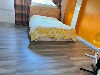a bed in a room with a wooden floor at Surrey central house in Surrey