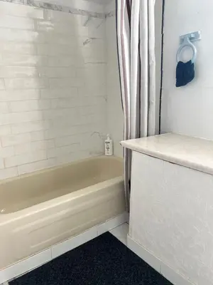 a bathroom with a tub and a shower curtain at Surrey central house in Surrey