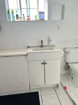 a white bathroom with a sink and a toilet at Surrey central house in Surrey