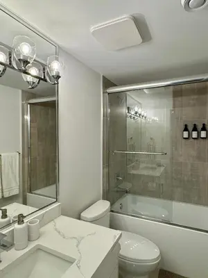 a bathroom with a toilet and a tub and a sink at Levida Living - Cozy 2 Bedroom Suite at the Heart of Langley in Langley