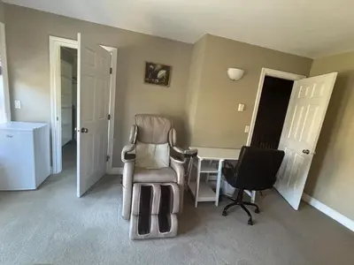 a room with a chair and a desk and two doors at Rosehouse 2Bedrooms sleep 4 2nd floor private bathroom in Coquitlam