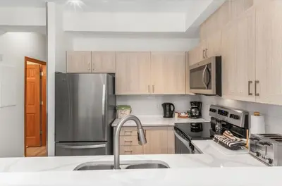 a kitchen with wooden cabinets and a stainless steel refrigerator at Whistler Village Condo Sleeps 7 in Whistler